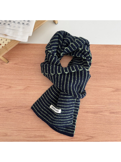 Dark Green striped knit scarf looped on a tabletop