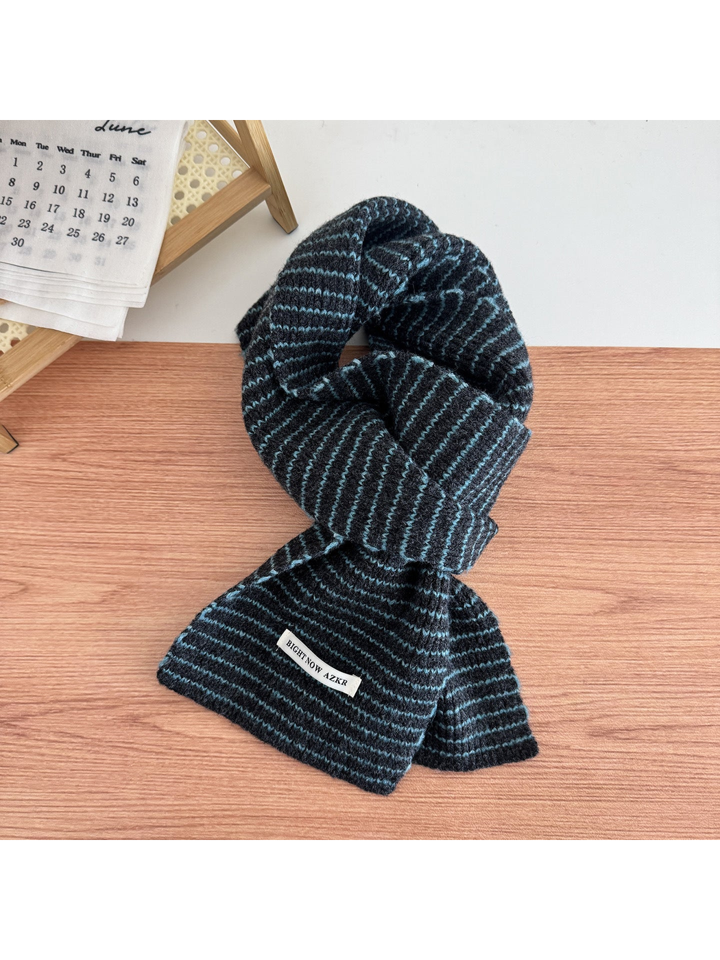 Gray Blue striped knit scarf looped on a tabletop