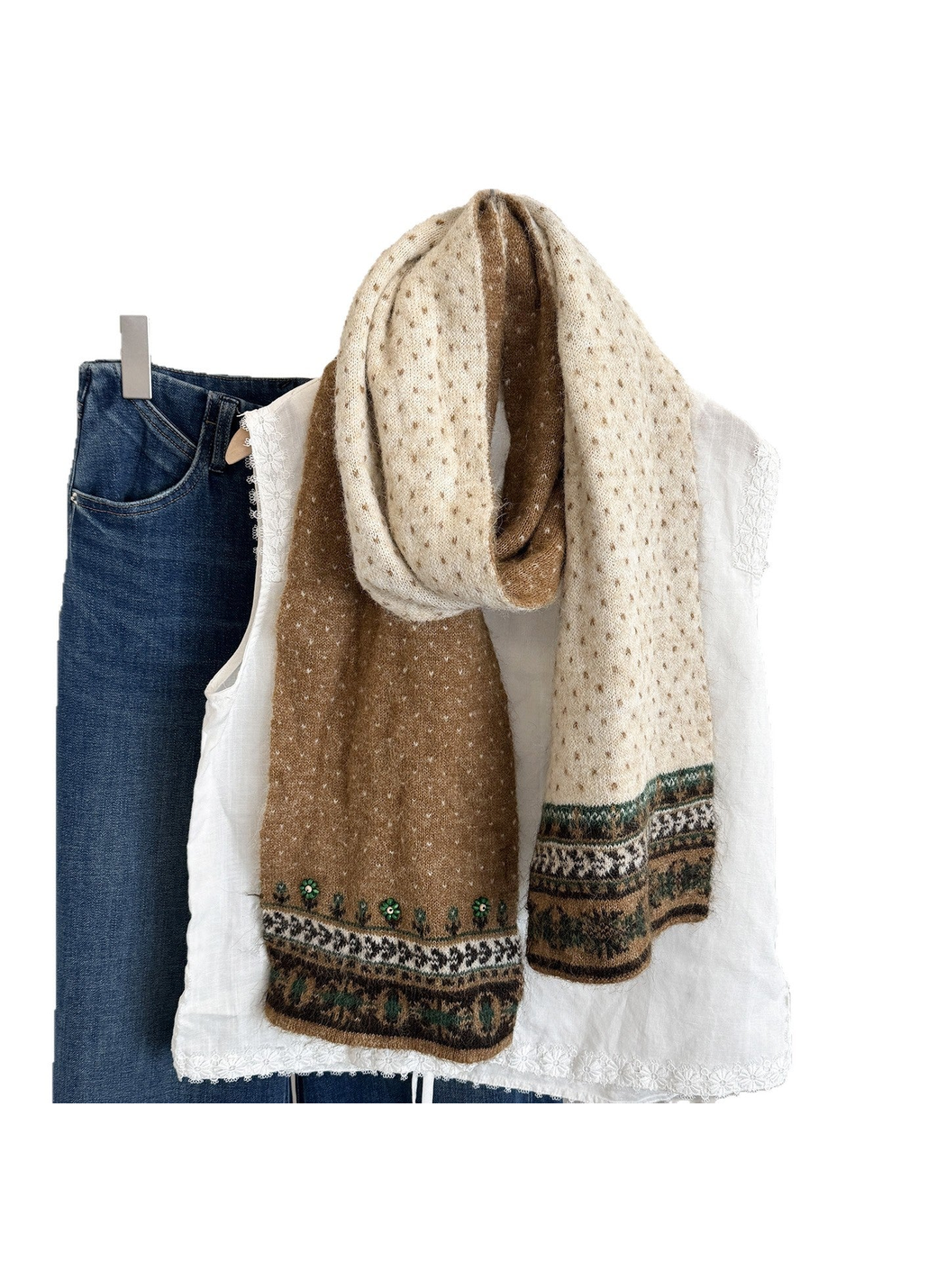 Patterned long scarf draped over a white blouse and denim.