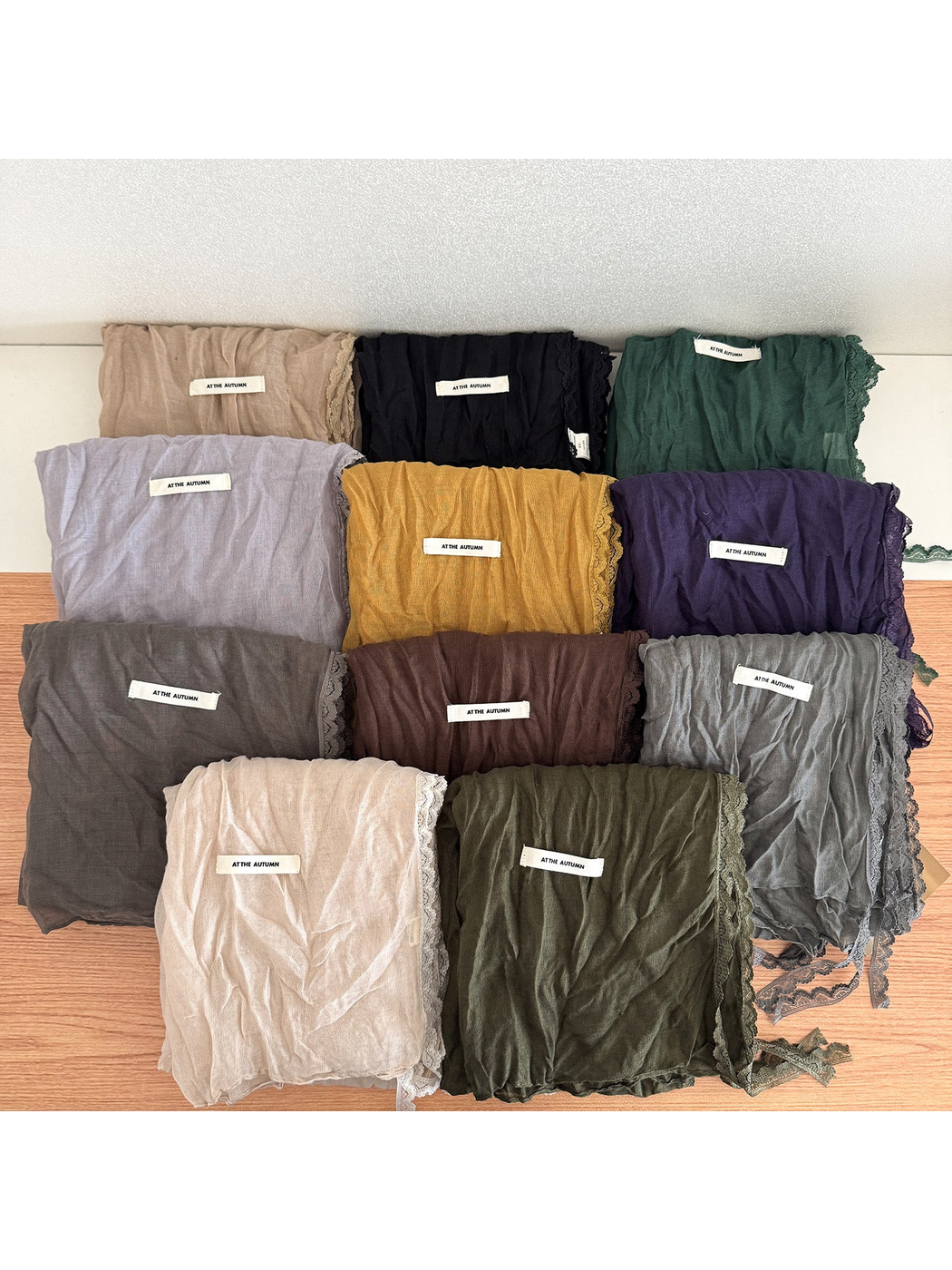 Multiple lace-edged scarves in assorted colors displayed together