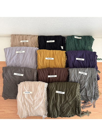 Multiple lace-edged scarves in assorted colors displayed together