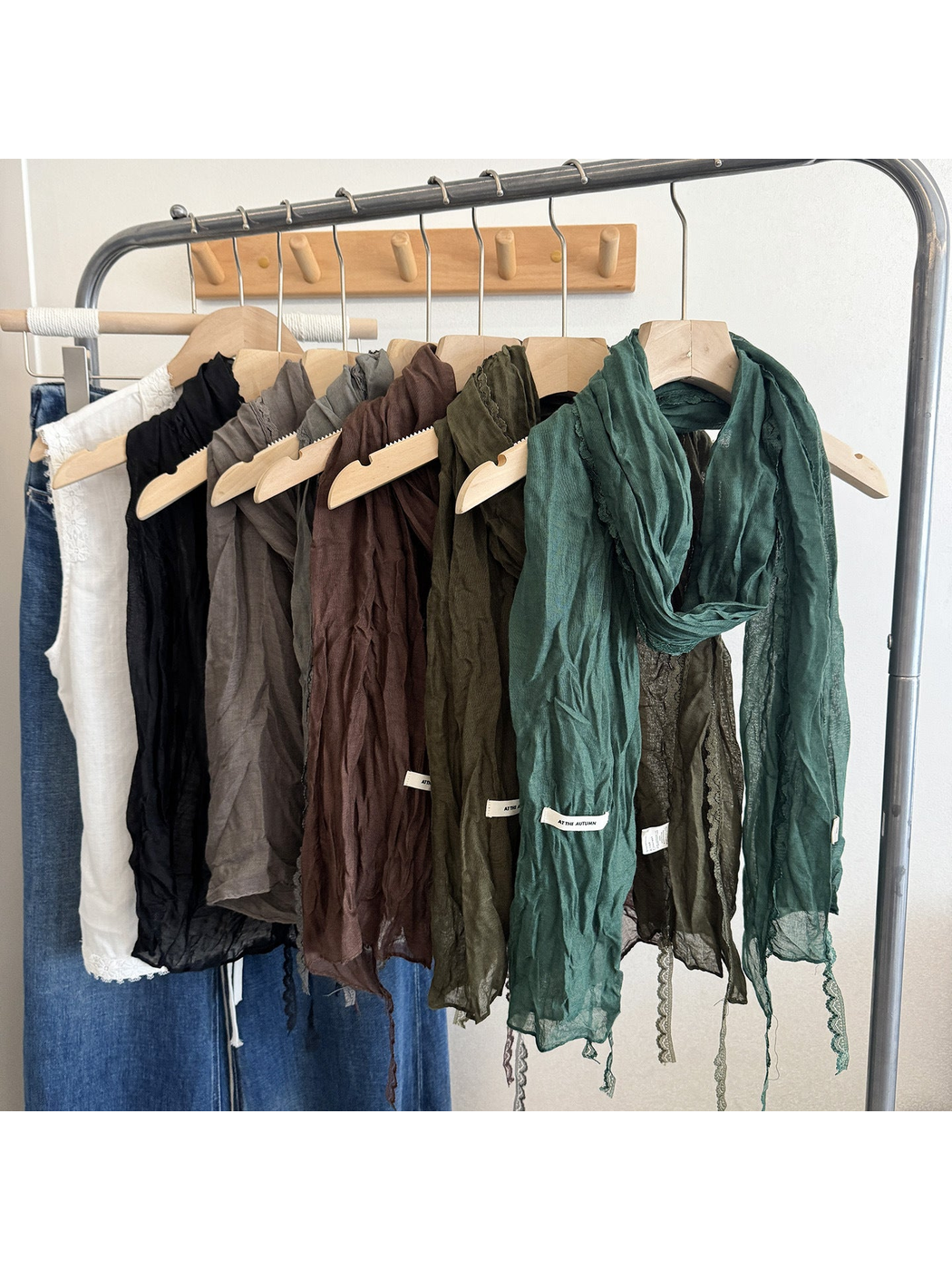 Multiple crinkled scarves hanging in a row with lace edging