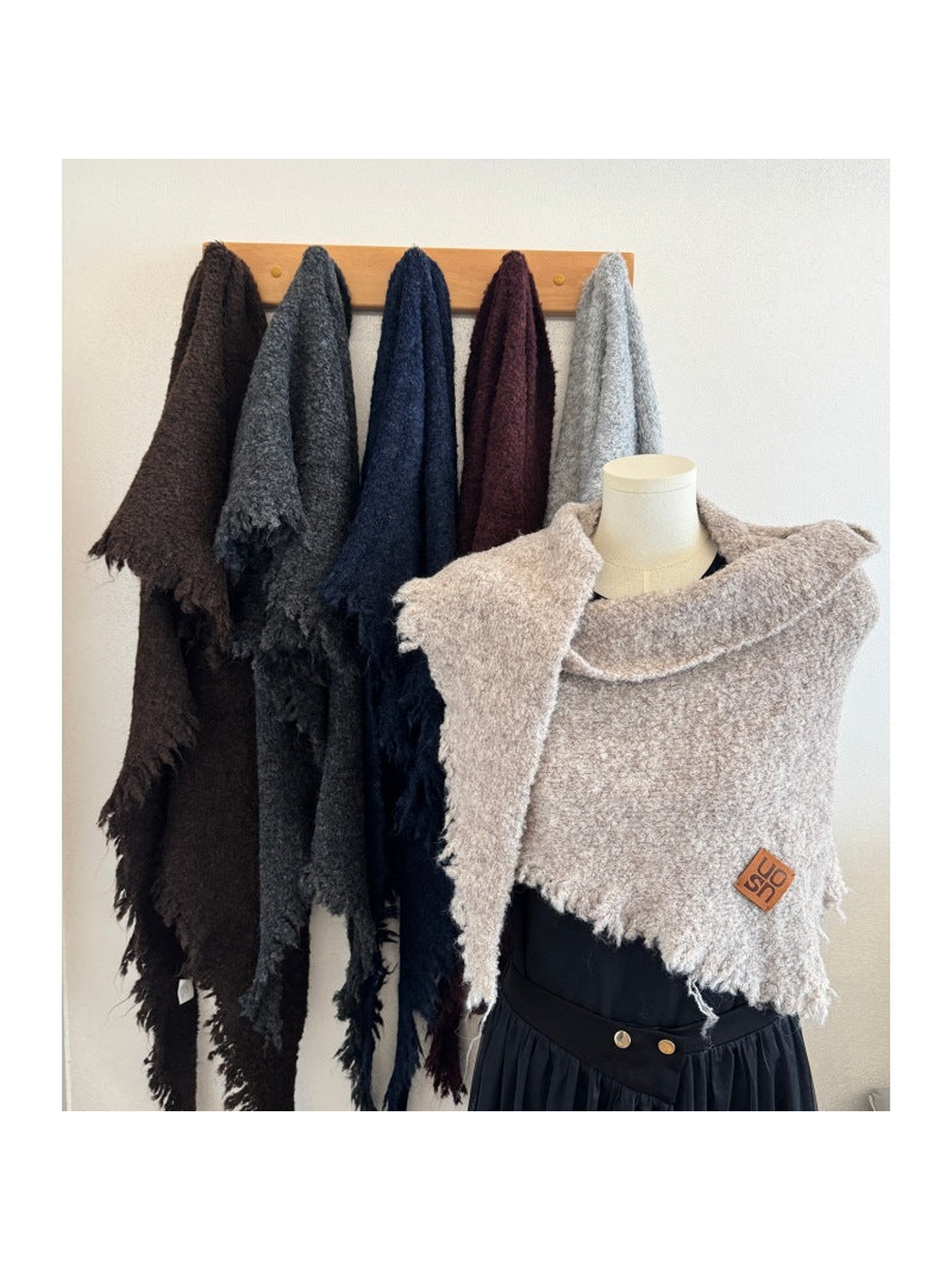 Multiple scarf colors displayed on a rack and mannequin
