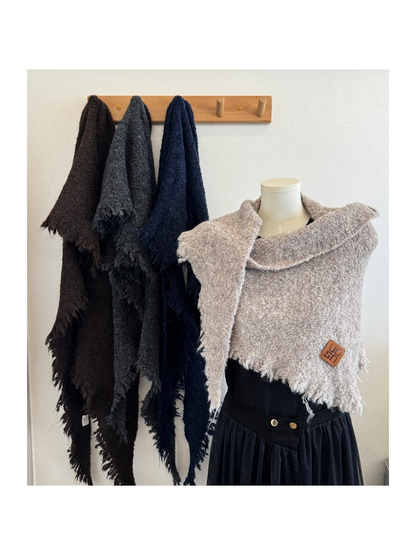 Multiple scarf colors displayed on a wall rack and mannequin