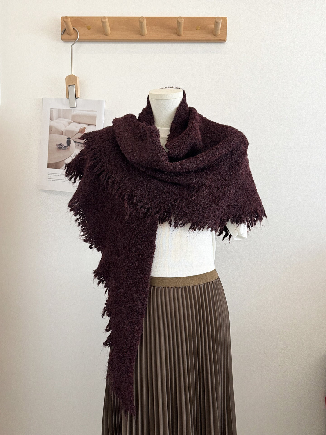 Burgundy textured scarf with fringed edges draped on a mannequin