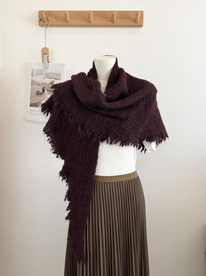 Burgundy textured scarf with fringed edges draped on a mannequin