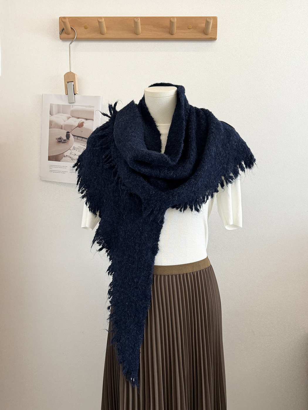 Navy textured scarf with fringed edges draped on a mannequin