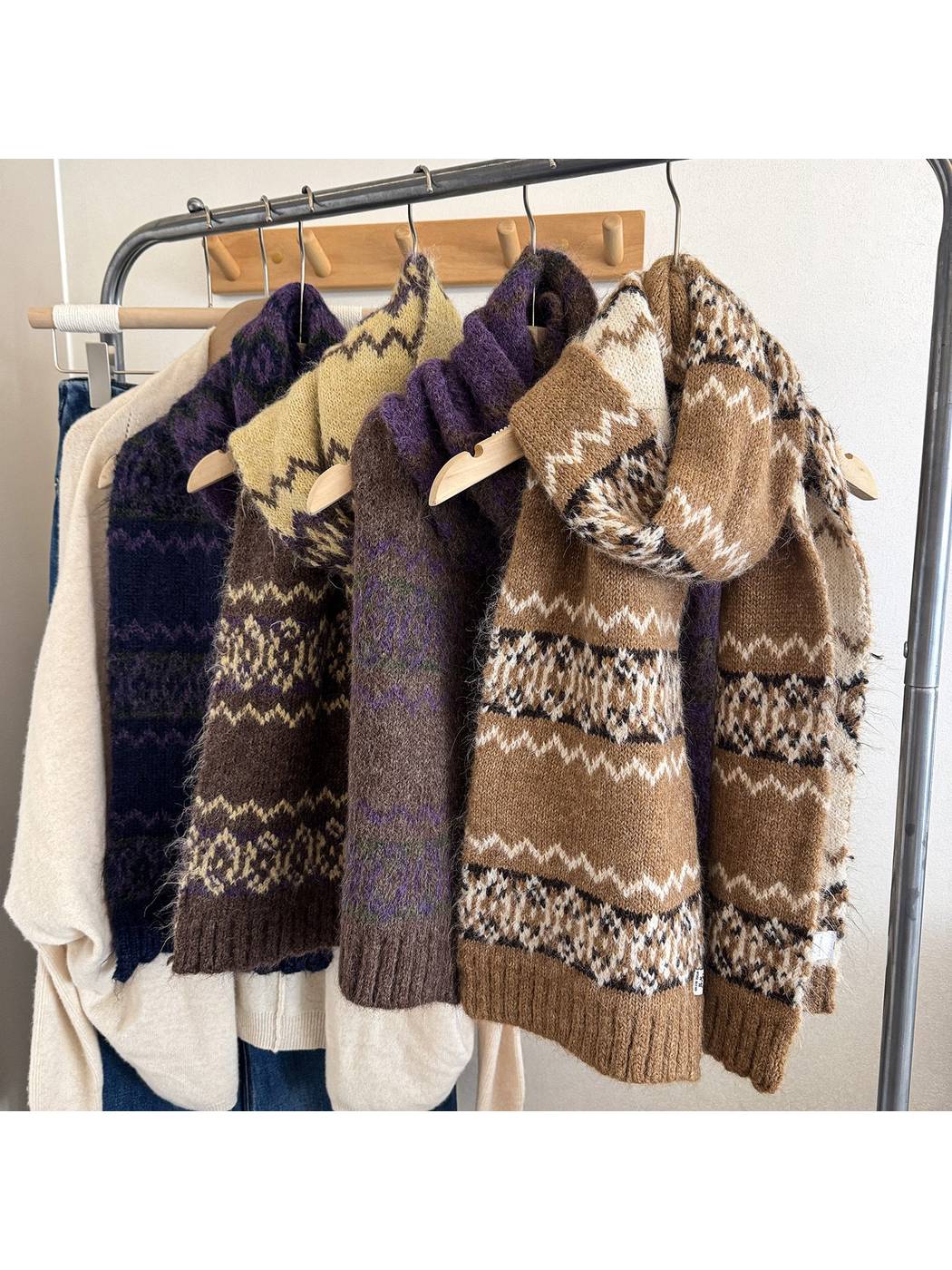 Multiple patterned scarves displayed on a clothing rack