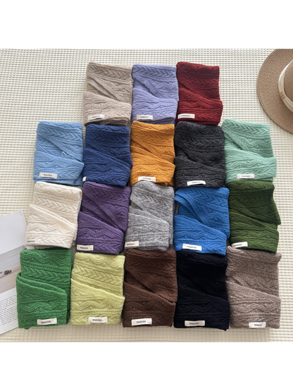 Triangle scarves in multiple colors folded and arranged together