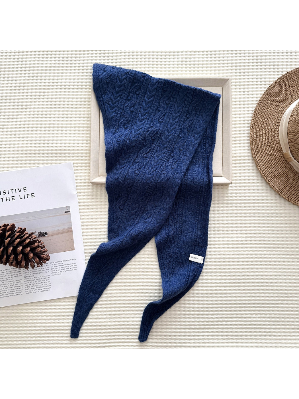 Navy textured triangle scarf draped over a frame
