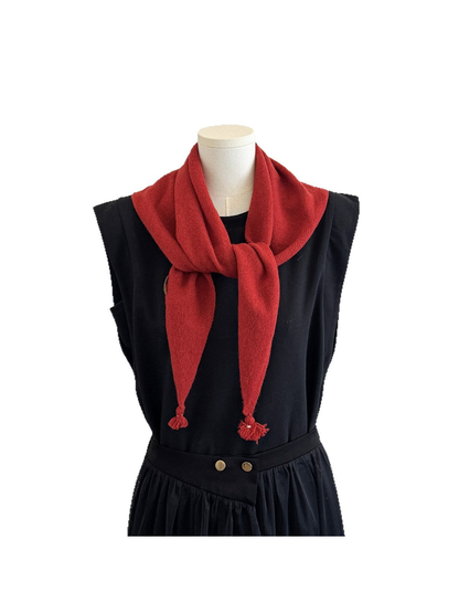 Red triangle scarf tied around a mannequin neck with tassel ends
