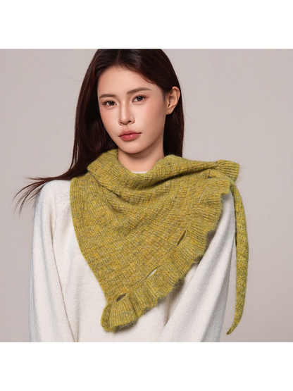 Woman wearing a mustard yellow triangle scarf over a white sweater