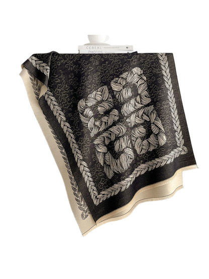 Black Gray scarf with a floral motif and braided border, draped over a shelf