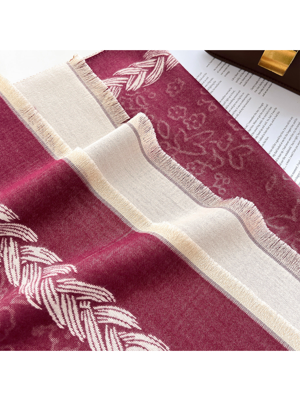 Burgundy scarf detail showing its floral pattern, braided border, and fringe