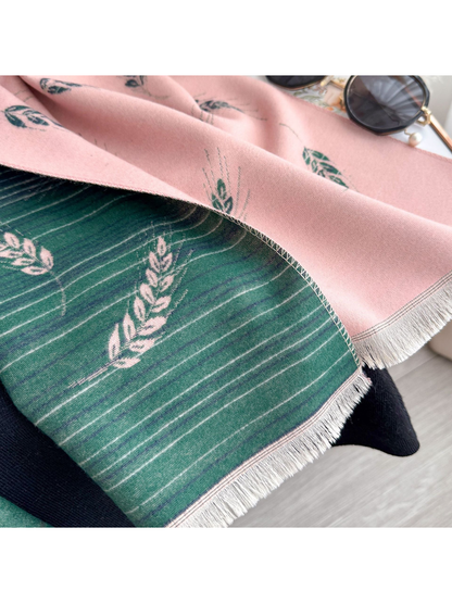 Close-up of a blush pink scarf's green striped reverse and fringed edge