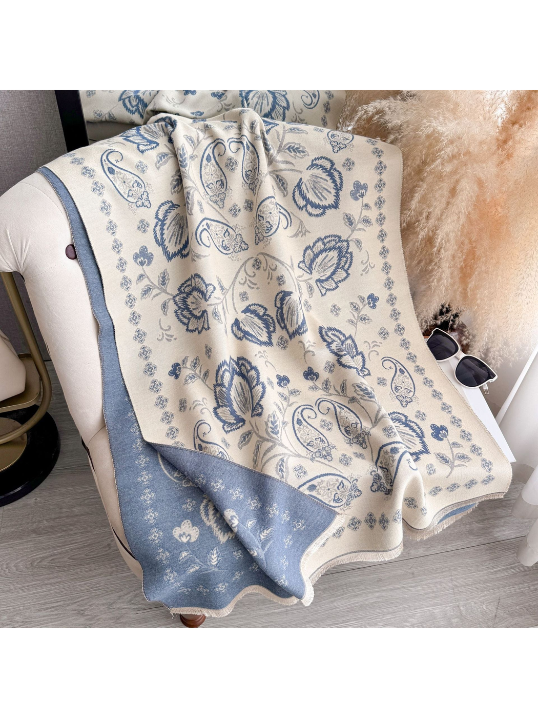 Light Blue floral and paisley scarf draped over a chair, with a contrasting reverse side and fringed edges