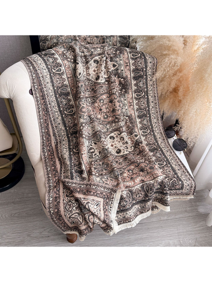 Blush paisley scarf with fringed edges draped over a chair