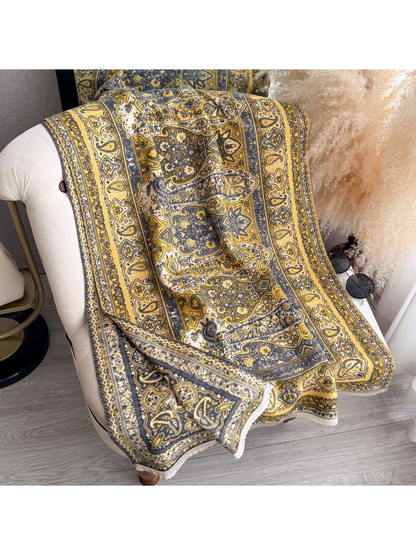 Mustard Yellow paisley scarf with fringed edges draped over a chair