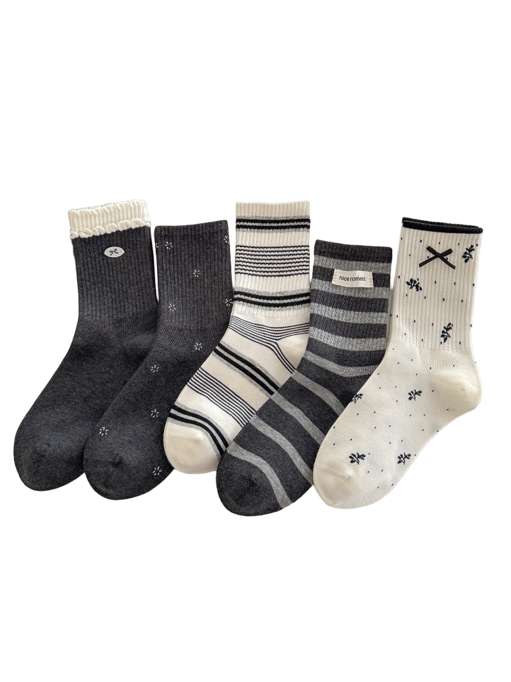 Five crew socks in dark and ivory patterns displayed on a tabletop