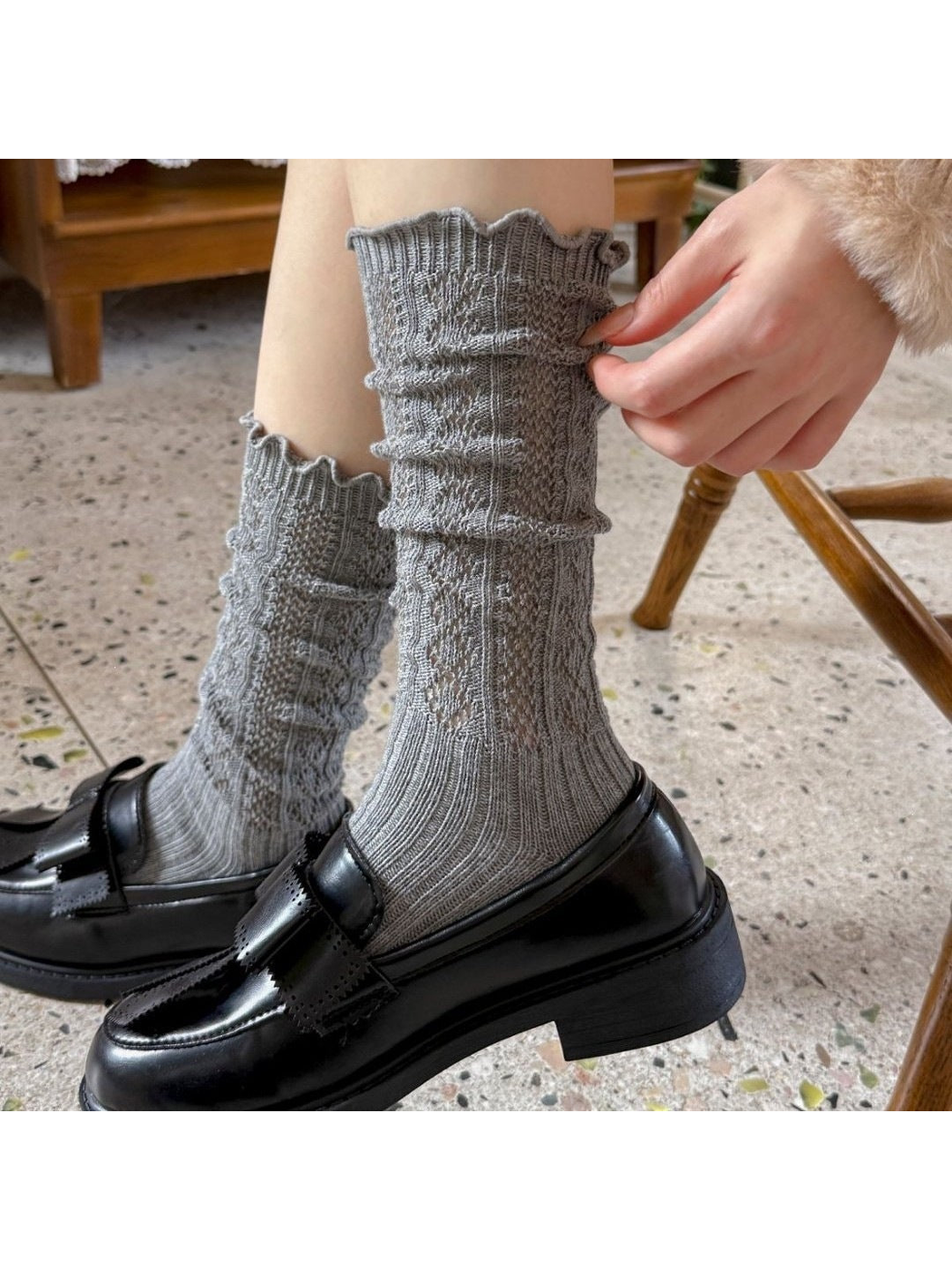 Gray patterned socks worn with black loafers