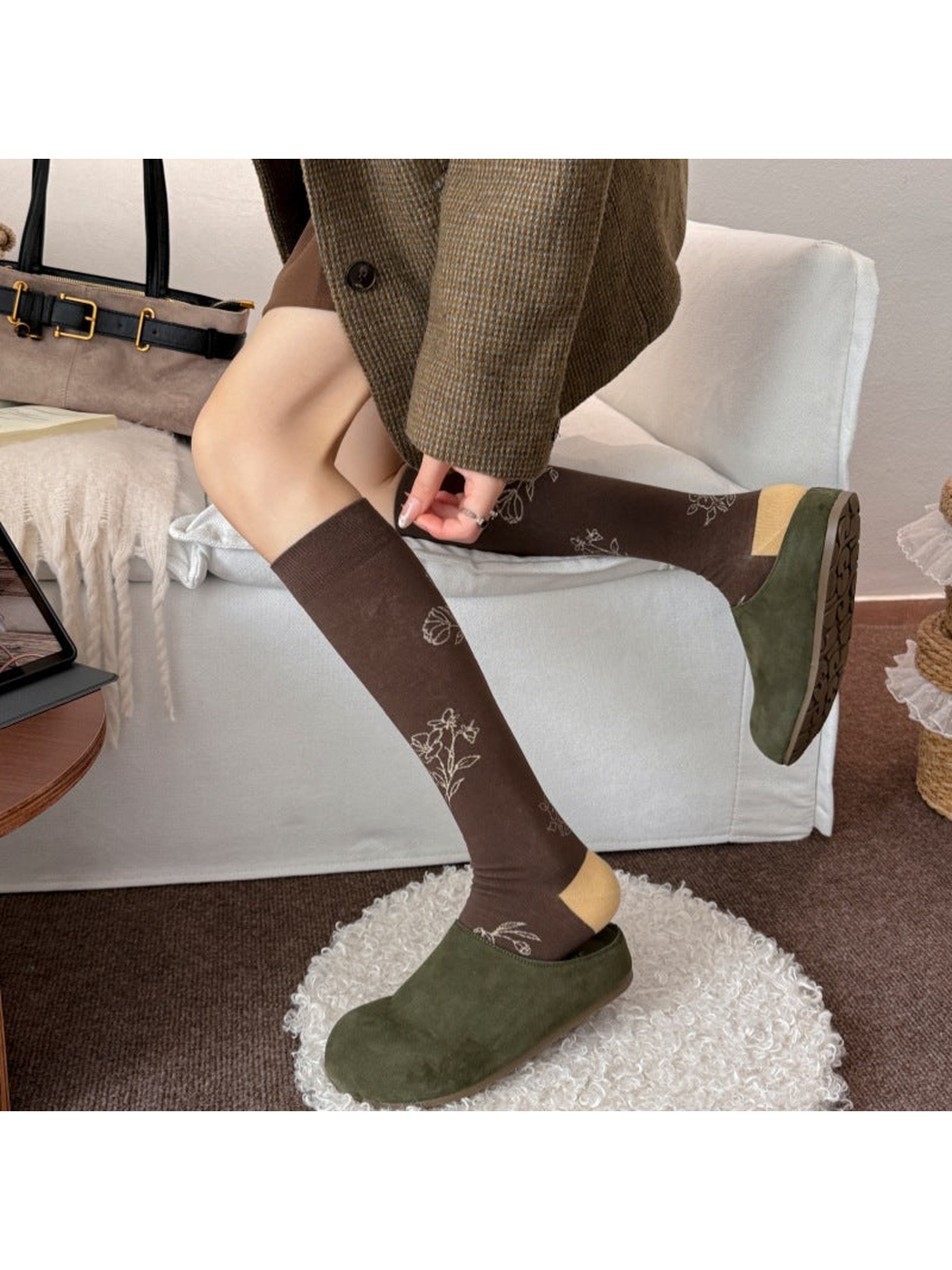 Coffee knee-high socks with floral motifs worn with green slip-on shoes