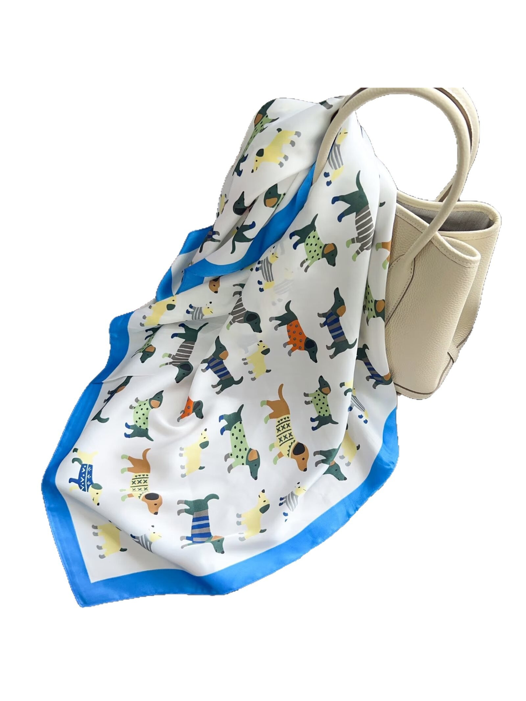 Blue dog-print scarf with a bright blue border draped over a cream handbag