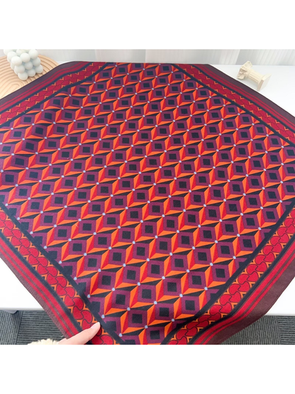 Red, orange, burgundy, and navy geometric square scarf laid flat