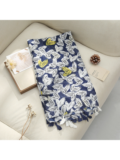 Navy scarf displayed flat with abstract butterfly-like motifs and tassel fringe
