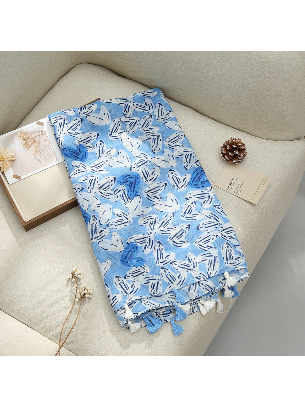 Light Blue scarf displayed flat with abstract butterfly-like motifs and tassel fringe