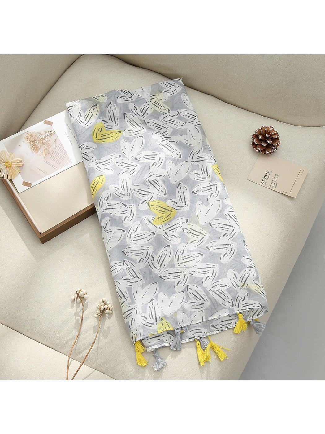 Gray scarf displayed flat with abstract butterfly-like motifs and tassel fringe