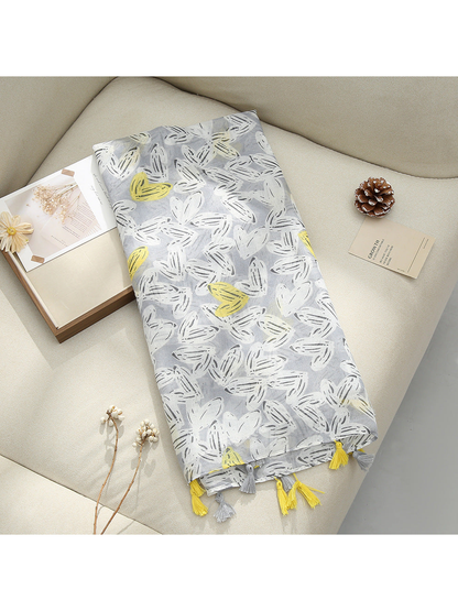 Gray scarf displayed flat with abstract butterfly-like motifs and tassel fringe