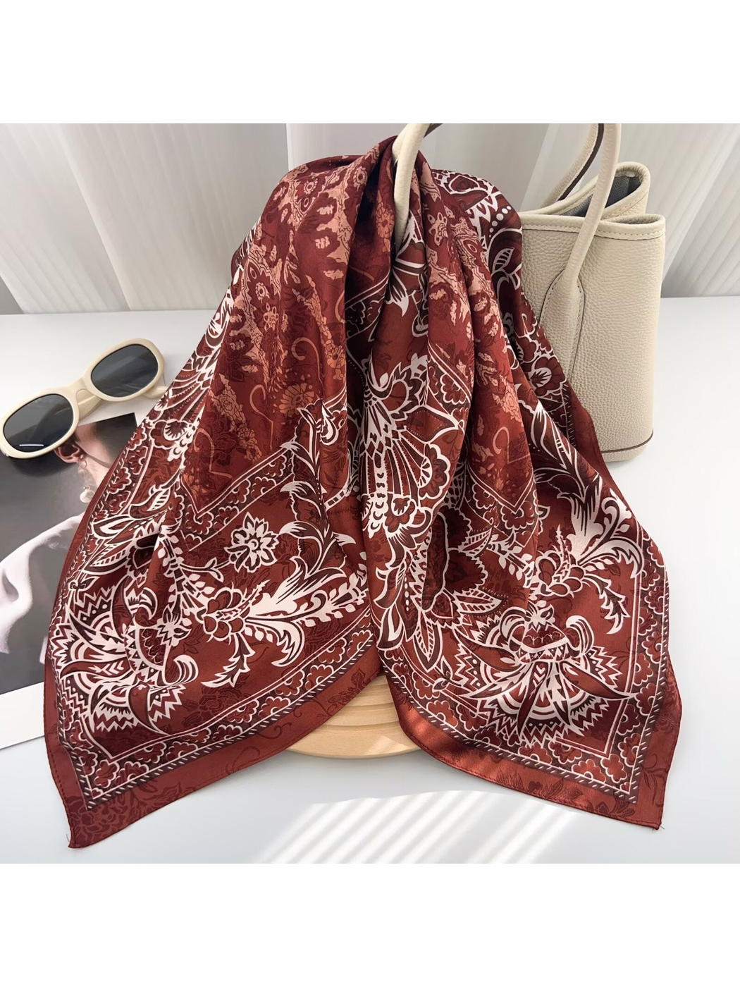Burgundy patterned scarf draped over a tote bag