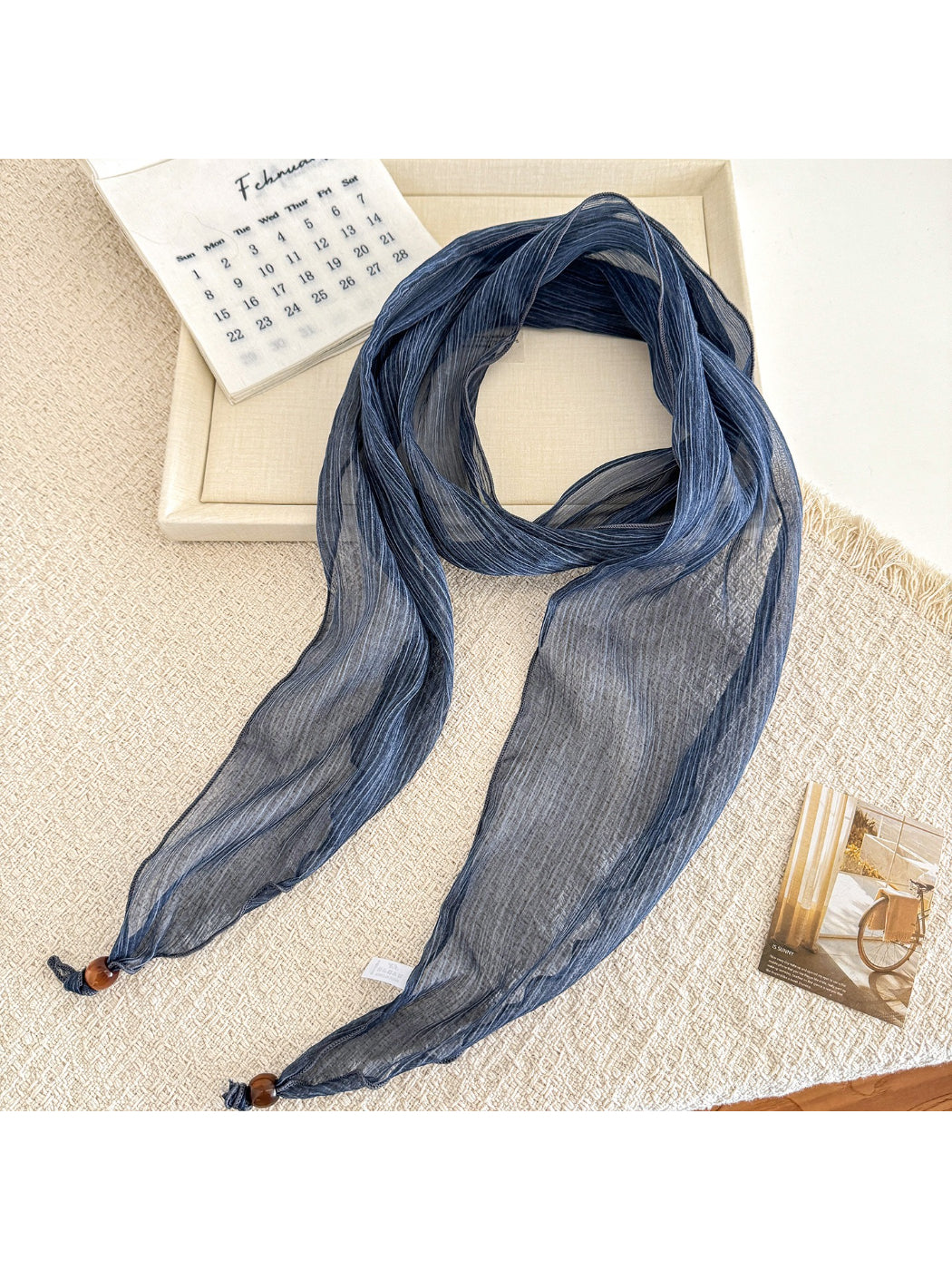 Soft pleated sheer skinny scarf loosely wrapped around a mannequin neck