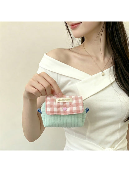 Cosbai cosmetic pouch in gingham pattern held in hand for size reference