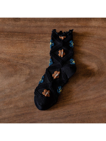 Model wearing Rufia floral mesh crew socks with casual shoes and cropped pants