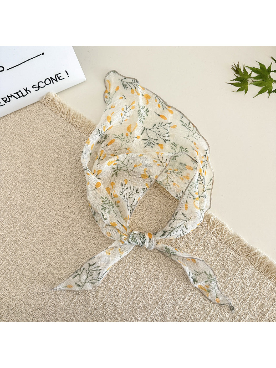 Floral triangle scarf folded neatly showing vibrant pink and green floral design