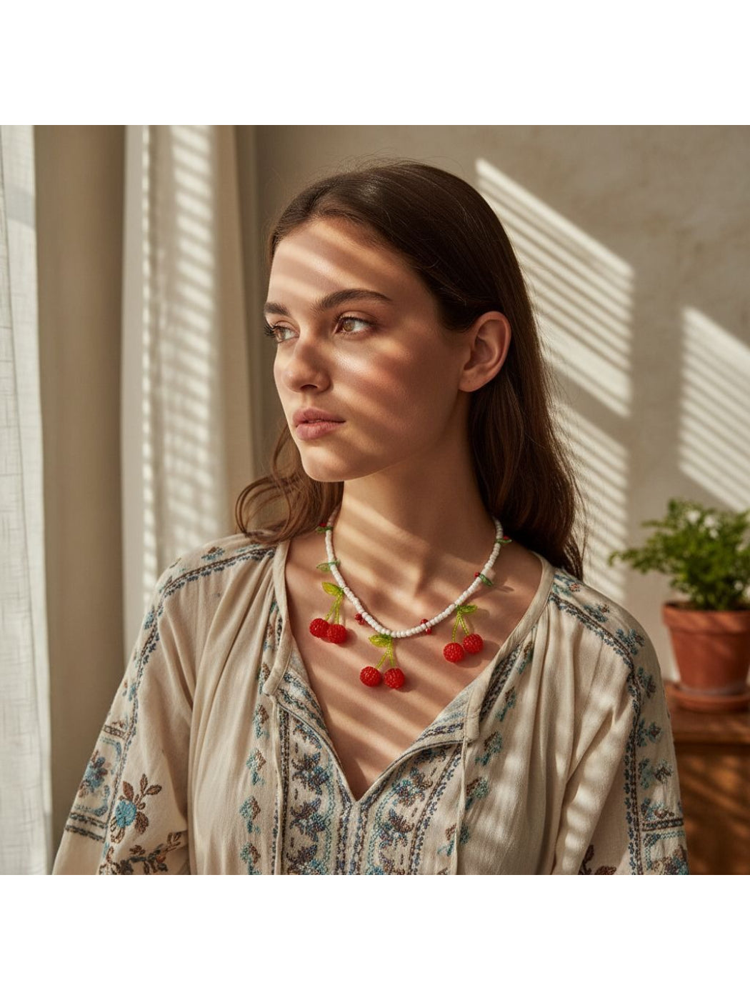 Neckit cherry pendant necklace with white beads displayed on a white background
