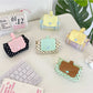 Cosbai mini pouch bag with white polka dots on black fabric, front view