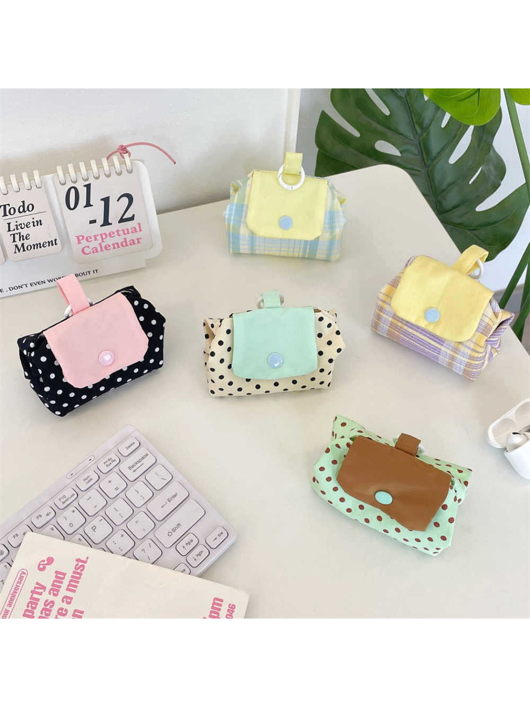 Cosbai mini pouch bag with white polka dots on black fabric, front view