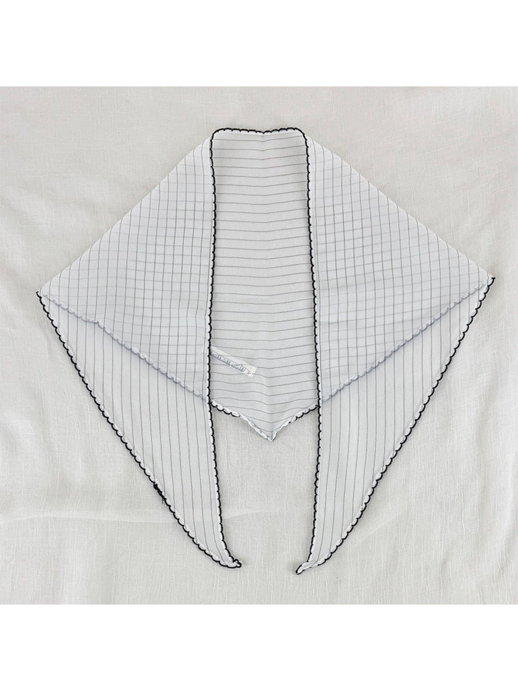 Scarvii triangle scarf folded to show pleats and black contrast edging