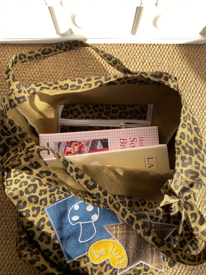 Cosbai leopard carry bag placed on urban sidewalk with graffiti background
