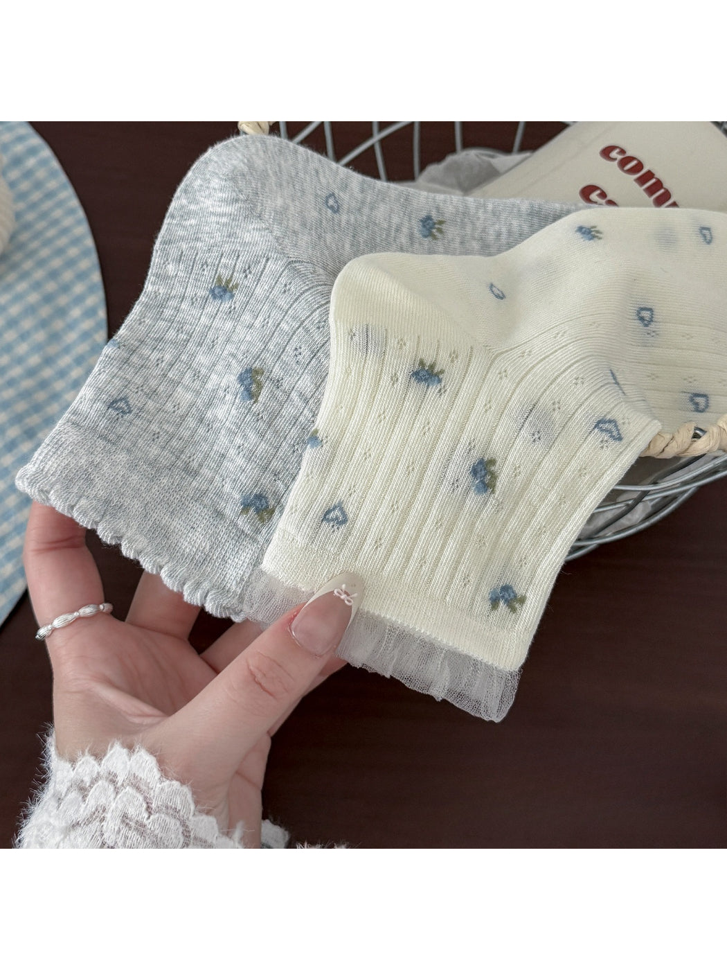 Pair of Rufia sheer crew socks with ruffle hem in white, flat lay on white background