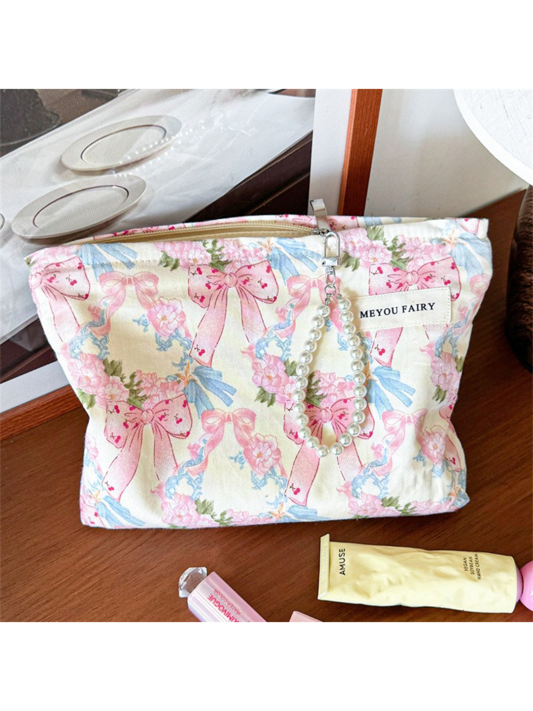 Cosbai cosmetic bag with bow and floral pattern on a white surface
