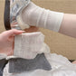 Pair of Rufia neutral textured crew socks laid flat showing full length and texture