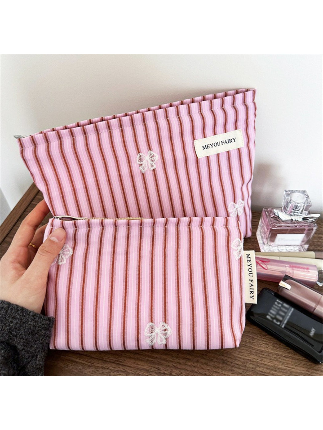 Close-up of pink stripe butterfly makeup bag showing butterfly design and fabric texture