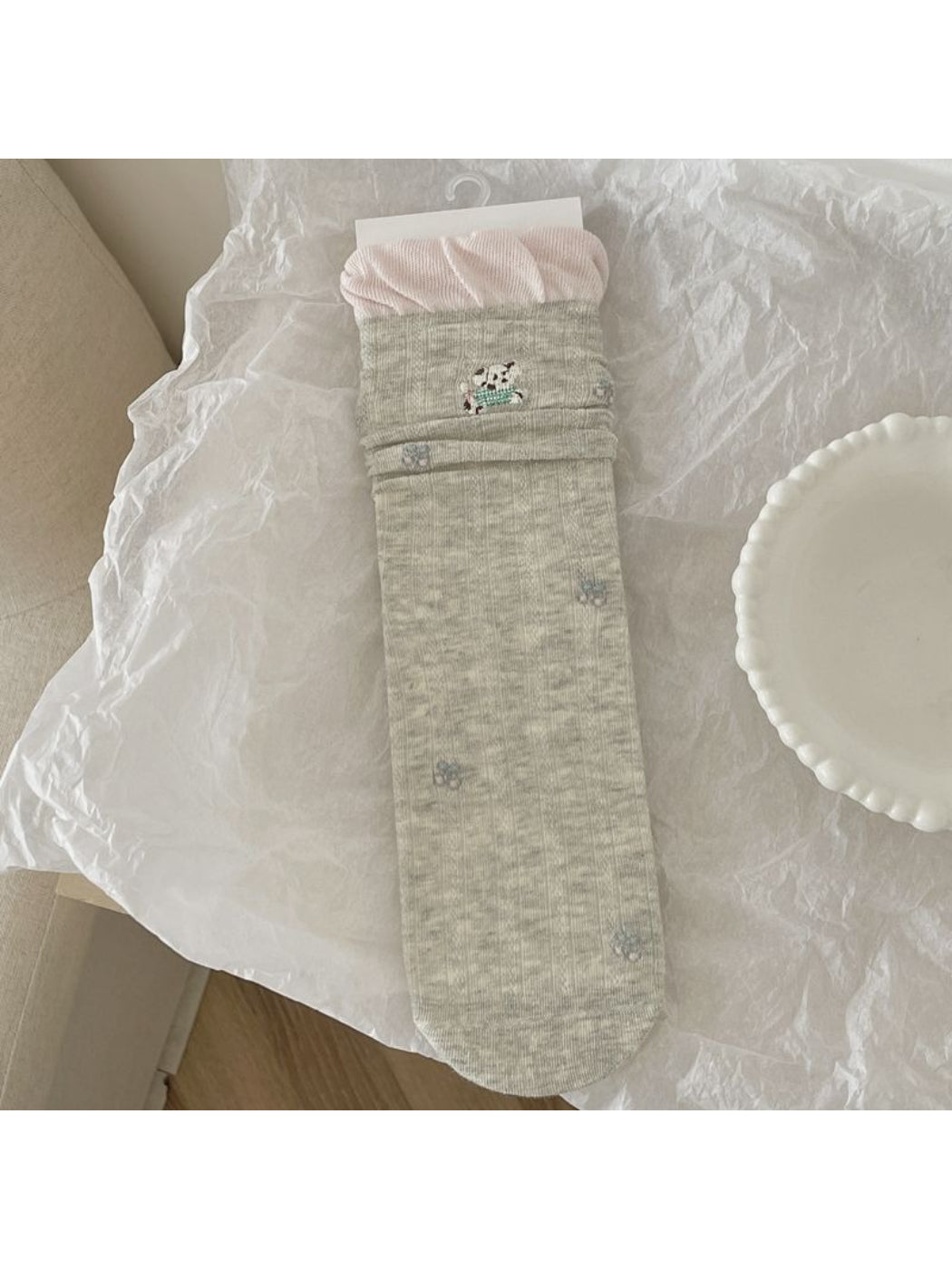 Pair of Rufia Sweet Animal Detail Crew Socks on wooden surface with soft light