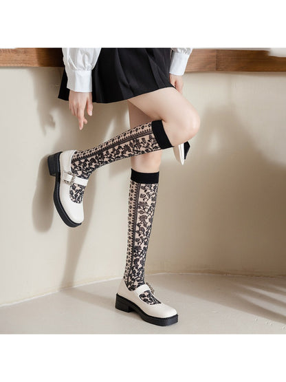 Side view of Rufia knee high sock showing intricate floral lace pattern