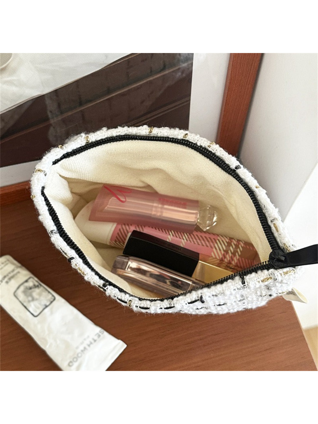 Cosbai makeup pouch placed on a vanity table with makeup brushes inside