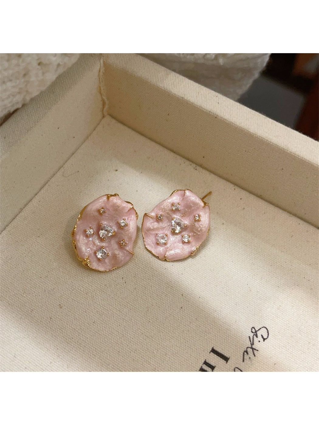 Earwish floral stud earrings worn on an ear, highlighting delicate design