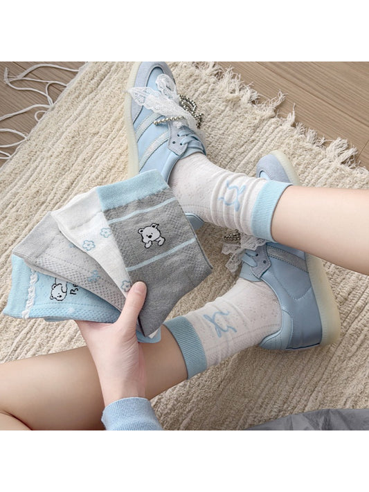 Pair of Rufia cute crew socks with blue accents laid flat on white background